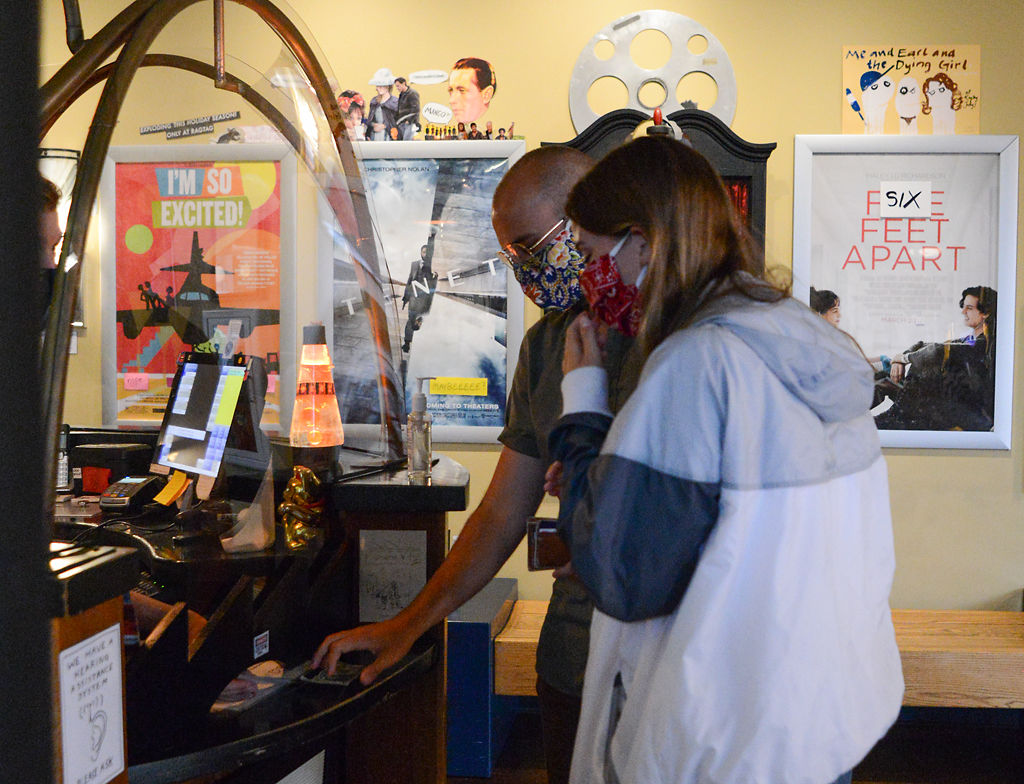 Grace Sanders, right, and Travis Agne claim their booked movie tickets